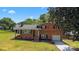 Charming brick home with a well-manicured lawn, attached garage, and inviting front porch under a sunny, blue sky at 5301 Baker Dr, Charlotte, NC 28210