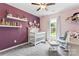 Cozy baby bedroom with lavender accent wall, white crib, floating shelves, soft carpet and lots of natural light at 5927 Patricia Ryan Dr, Charlotte, NC 28216