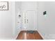 Clean and bright foyer with hardwood floors, a white front door, and a modern security system at 5927 Patricia Ryan Dr, Charlotte, NC 28216
