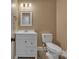 Well-lit half bathroom with white vanity, toilet, and neutral wall color at 63 Frost Ln, Taylorsville, NC 28681
