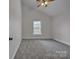 A spacious room with plush gray carpet, a large window, and a vaulted ceiling at 63 Frost Ln, Taylorsville, NC 28681