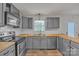 Updated kitchen with stainless appliances, wooden countertops, and tile backsplash at 63 Frost Ln, Taylorsville, NC 28681