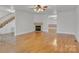 Open concept living area with hardwood floors, fireplace, and staircase leading to upper level at 63 Frost Ln, Taylorsville, NC 28681