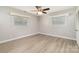 Empty bedroom featuring two windows, ceiling fan, and vinyl floors at 6325 Elmwood Cir, Charlotte, NC 28214