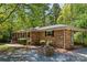 Charming brick home featuring mature landscaping, quaint flowerbed, and an attached carport, all nestled in a peaceful setting at 6325 Elmwood Cir, Charlotte, NC 28214