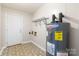 Utility room with water heater, overhead rack, and exterior door at 6325 Elmwood Cir, Charlotte, NC 28214