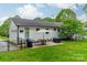 Lush backyard featuring a patio, an outdoor grill, and well-maintained green space with overhead string lights at 6339 Montpelier Rd, Charlotte, NC 28210