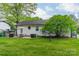 Lush backyard featuring a patio, an outdoor grill, and well-maintained green space with mature shade trees at 6339 Montpelier Rd, Charlotte, NC 28210