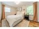 Bright bedroom with white linens, warm lighting, and beautiful hardwood floors beneath a stylish area rug at 6339 Montpelier Rd, Charlotte, NC 28210