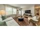 Bright living room featuring a plush sofa, a stylish rug, and large windows for natural light at 6339 Montpelier Rd, Charlotte, NC 28210