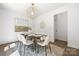 Dining room with contemporary chandelier, art, a dining table set for six, and a neutral rug at 6524 Robert St, Huntersville, NC 28078
