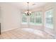 Bright breakfast nook with many windows, neutral tile flooring, and decorative chandelier at 7206 Forrest Rader Dr, Mint Hill, NC 28227