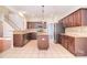 Kitchen features an island, stainless appliances, granite countertops, tile flooring, and wood cabinets at 7206 Forrest Rader Dr, Mint Hill, NC 28227