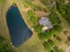 Stunning aerial view of a home next to a beautiful pond with landscaped yard, perfect for outdoor enjoyment and privacy at 7701 Gold Hill Rd, Rockwell, NC 28138