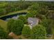 Aerial view of the property with mature trees and a large pond at 7701 Gold Hill Rd, Rockwell, NC 28138