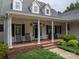 Inviting covered front porch with rocking chairs and brick flooring at 7701 Gold Hill Rd, Rockwell, NC 28138
