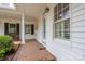 Covered front porch with brick flooring and bright white trim at 7701 Gold Hill Rd, Rockwell, NC 28138