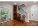 Living room featuring wood floors, custom built in book shelves and staircase at 7701 Gold Hill Rd, Rockwell, NC 28138