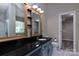 Modern bathroom featuring a granite countertop, vanity, and a separate door leading to the closet at 8607 Cedardale Ridge Ct, Charlotte, NC 28269