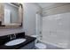 Bathroom with a gray vanity, dark countertop, an enclosed bathtub, and a framed mirror at 8607 Cedardale Ridge Ct, Charlotte, NC 28269