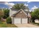 Two-story home featuring a stone facade, two-car garage, and a well-manicured lawn at 8607 Cedardale Ridge Ct, Charlotte, NC 28269