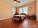 Cozy bedroom with hardwood floors, ceiling fan, bench and natural light from the windows at 8664 Nc 742 S Hwy, Wadesboro, NC 28170