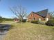 Brick home with red barn, surrounded by green yard at 8664 Nc 742 S Hwy, Wadesboro, NC 28170