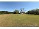 Picturesque view of a home and outbuildings set amidst a vast green field at 8664 Nc 742 S Hwy, Wadesboro, NC 28170