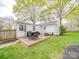Spacious backyard deck with outdoor seating and a grill, perfect for entertaining in a landscaped yard at 901 Burnley Rd, Charlotte, NC 28210