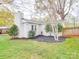 Exterior view of backyard features mature trees, lush landscaping and partial view of a deck at 901 Burnley Rd, Charlotte, NC 28210