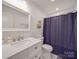 Clean bathroom features a bright vanity, modern fixtures, and a shower with blue curtain at 901 Burnley Rd, Charlotte, NC 28210