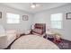Bright Bedroom with white trim features a ceiling fan, crib, rug, and an accent chair at 901 Burnley Rd, Charlotte, NC 28210