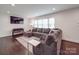 Comfortable living room with dark hardwood floors, large sofa and natural light at 901 Burnley Rd, Charlotte, NC 28210