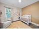 Comfortable Bedroom with a cream-colored crib, patterned rug, and playful wall decor for a warm, inviting feel at 101 Cross Current Ln # 137, Belmont, NC 28012