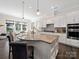 Bright kitchen featuring an island with seating, granite countertops, white cabinetry, and stainless steel appliances at 101 Cross Current Ln # 137, Belmont, NC 28012