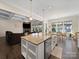 Open-concept floor plan with a kitchen island, stainless appliances, and a living room with a stone fireplace at 101 Cross Current Ln # 137, Belmont, NC 28012