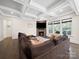 This spacious living room has a stone fireplace, coffered ceilings, and large windows letting in natural light at 101 Cross Current Ln # 137, Belmont, NC 28012