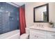 Stylish bathroom with blue tiled shower, modern vanity and mirror, and a bright, clean aesthetic at 1021 Vickie Ln, Matthews, NC 28104