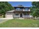 Charming two-story home featuring a welcoming front porch, landscaped yard, and attached two-car garage at 1021 Vickie Ln, Matthews, NC 28104