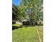 Tan single-story home featuring a lush lawn and mature trees at 104 Poplar St, Clover, SC 29710