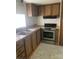 Well-lit kitchen with stainless steel appliances, wood cabinets, and double basin sink at 104 Poplar St, Clover, SC 29710
