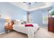 Bright bedroom with a tray ceiling, two windows, a nightstand, and a large bed at 11447 Potters Row, Cornelius, NC 28031