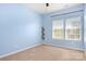 A carpeted bedroom is bathed in natural light, featuring bright blue walls and a ceiling fan at 11447 Potters Row, Cornelius, NC 28031