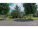 Landscaped neighborhood entrance with shrubbery and view of homes at 11447 Potters Row, Cornelius, NC 28031