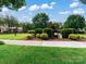 Neighborhood entrance with landscaping and trees, plus a view of nearby homes at 11447 Potters Row, Cornelius, NC 28031