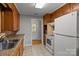 Traditional kitchen with wood cabinets, tile floor, stainless sink, and white appliances at 1230 Shearers Rd, Mooresville, NC 28115
