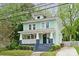 Charming two-story home with a covered front porch, painted in a refreshing light green with blue trim at 1327 Fairmont St, Charlotte, NC 28216