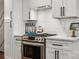 Close-up of a modern stove with stainless steel appliances, white cabinetry, and sleek design at 1327 Fairmont St, Charlotte, NC 28216