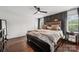 This main bedroom offers natural light, a ceiling fan, and beautiful dark wood floors at 1327 Fairmont St, Charlotte, NC 28216