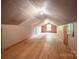Unfinished attic space with hardwood floors and a window that provides natural light at 1501 Nc Hwy 73 Hwy, Iron Station, NC 28080
